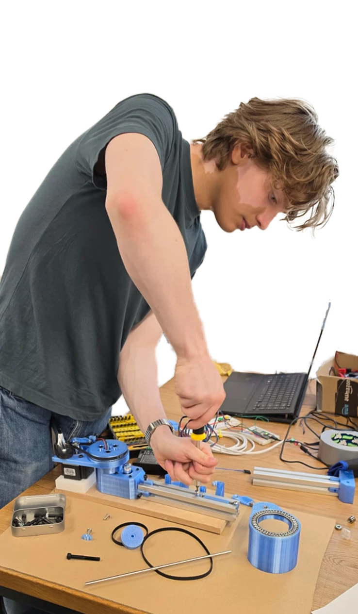 Ruaridh at a workbench screwing together a 3D-printed mechanism